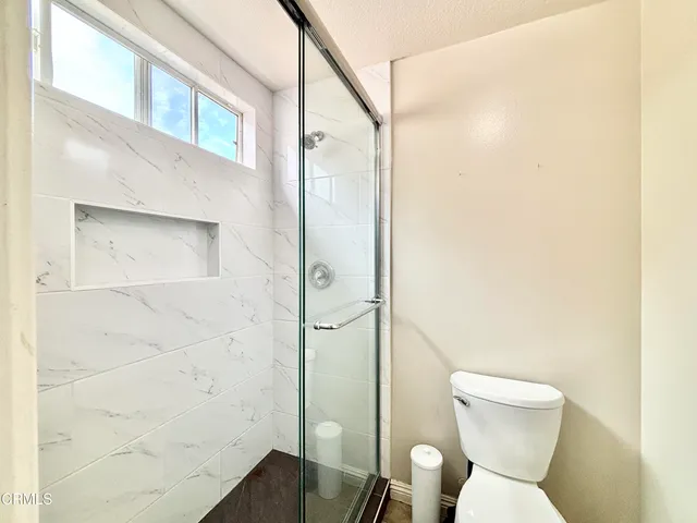 a bathroom with a toilet and a shower