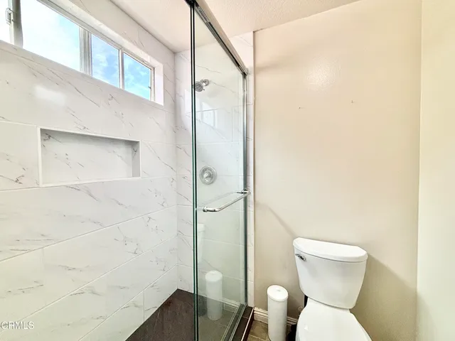 a bathroom with a toilet and a shower