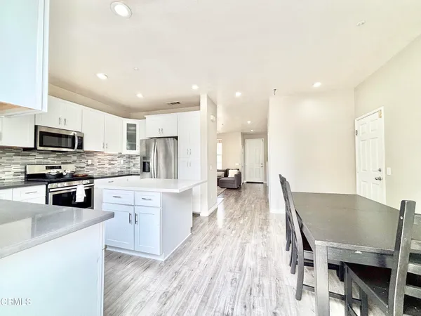 a large kitchen with a table and chairs in it