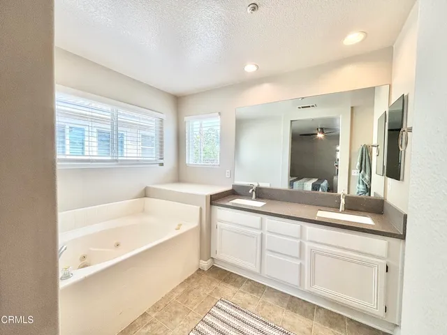 a bathroom with a tub sink and mirror
