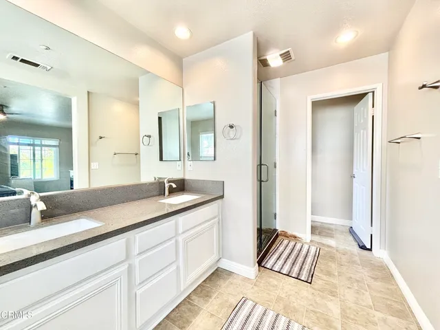 a spacious bathroom with a granite countertop sink and a mirror