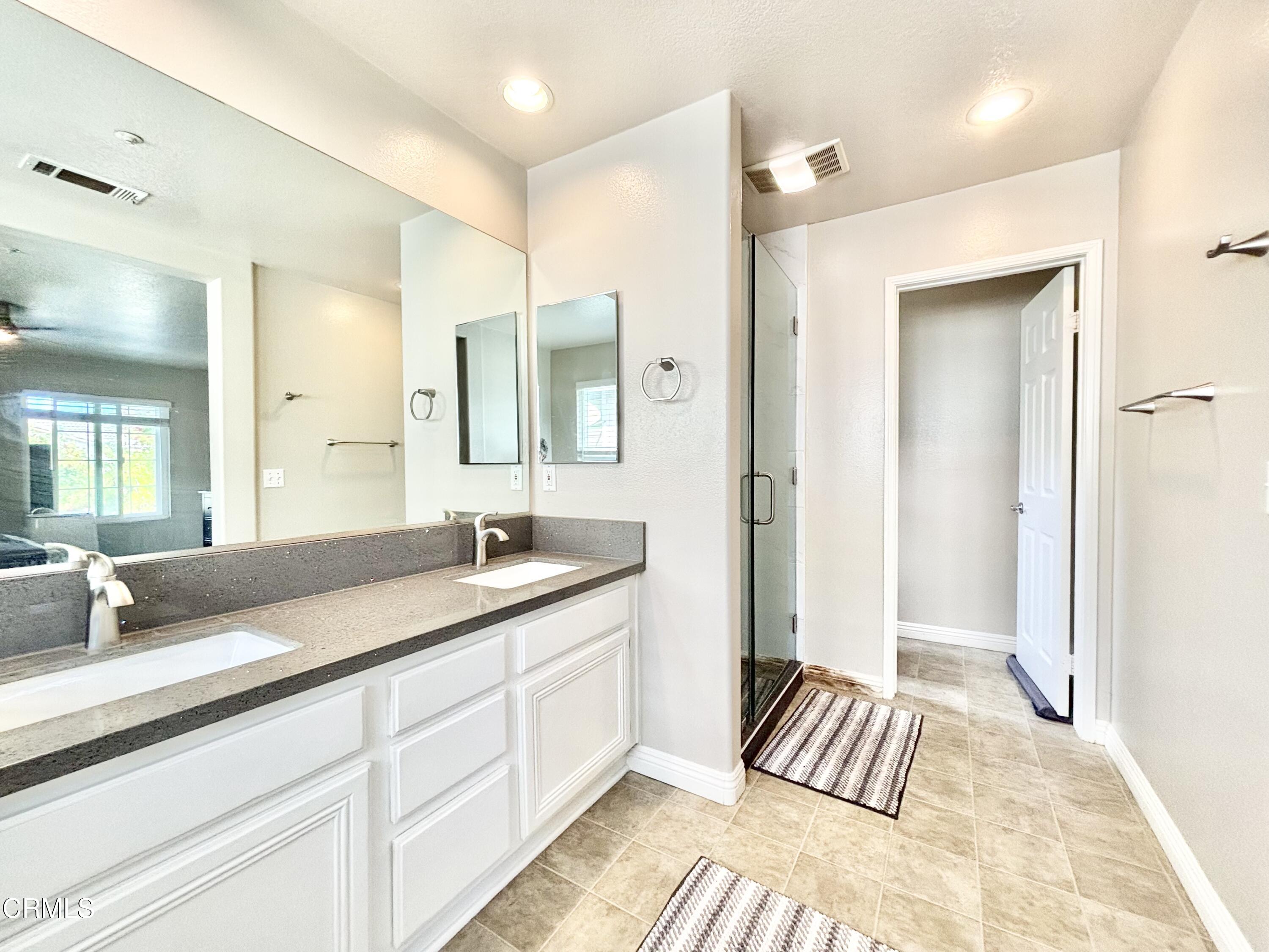 818 Navigator Way Oxnard, CA 93035 - Photo 7 of 29 a spacious bathroom with a granite countertop sink and a mirror