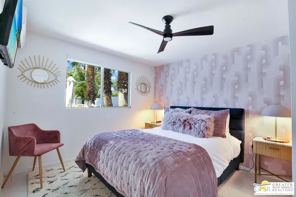 a bedroom with a large bed and a chair