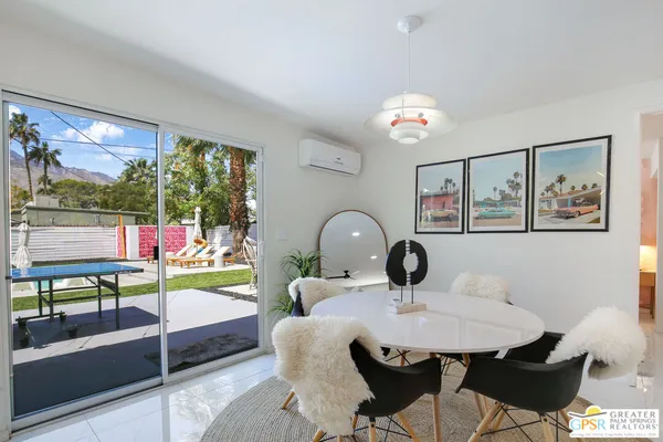 a view of a dining room with furniture a chandelier and window