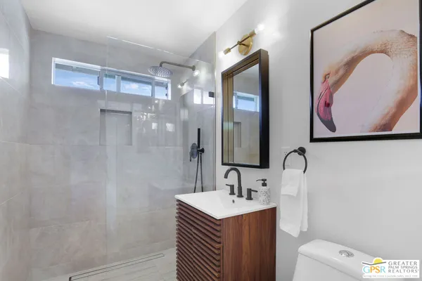 a bathroom with a sink vanity mirror and toilet