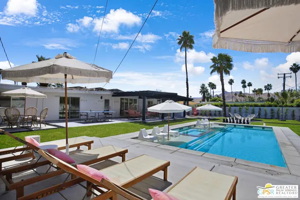 a view of a swimming pool with a patio and a yard