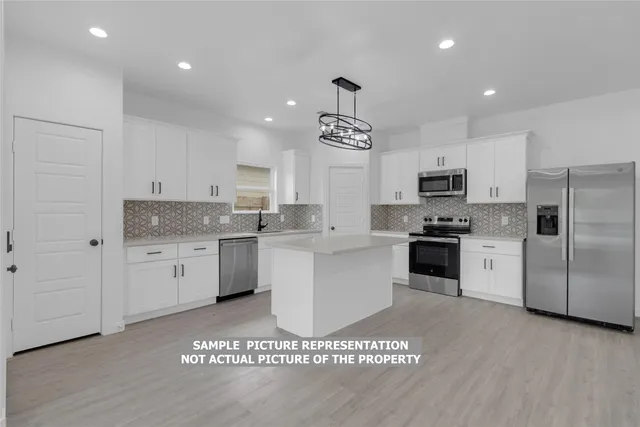 a kitchen with a refrigerator sink and cabinets