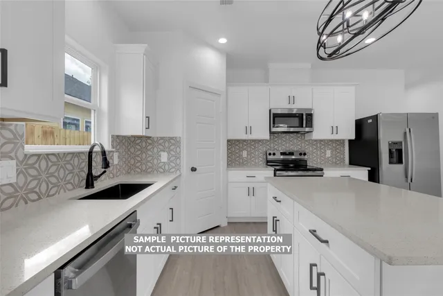 a kitchen with stainless steel appliances a sink stove and refrigerator