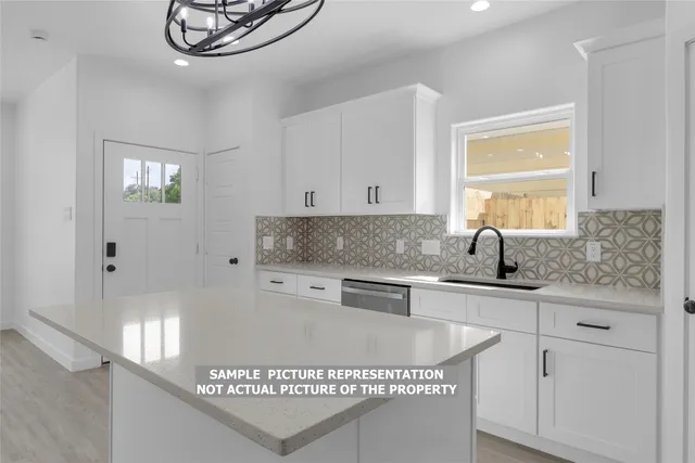 a kitchen with stainless steel appliances granite countertop a sink a stove and white cabinets