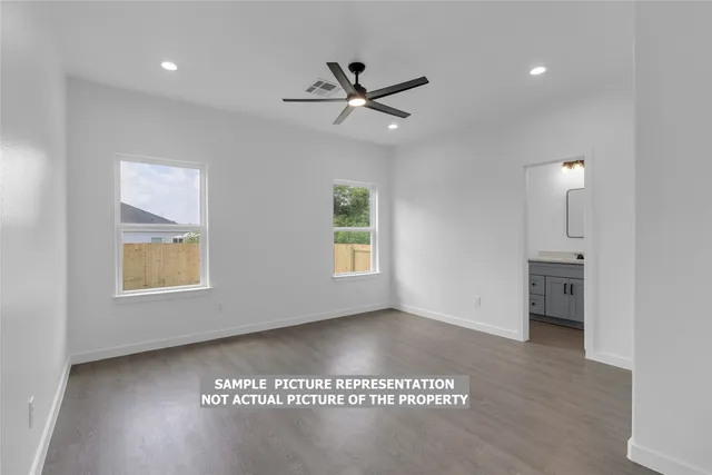a view of a big room with wooden floor and a ceiling fan