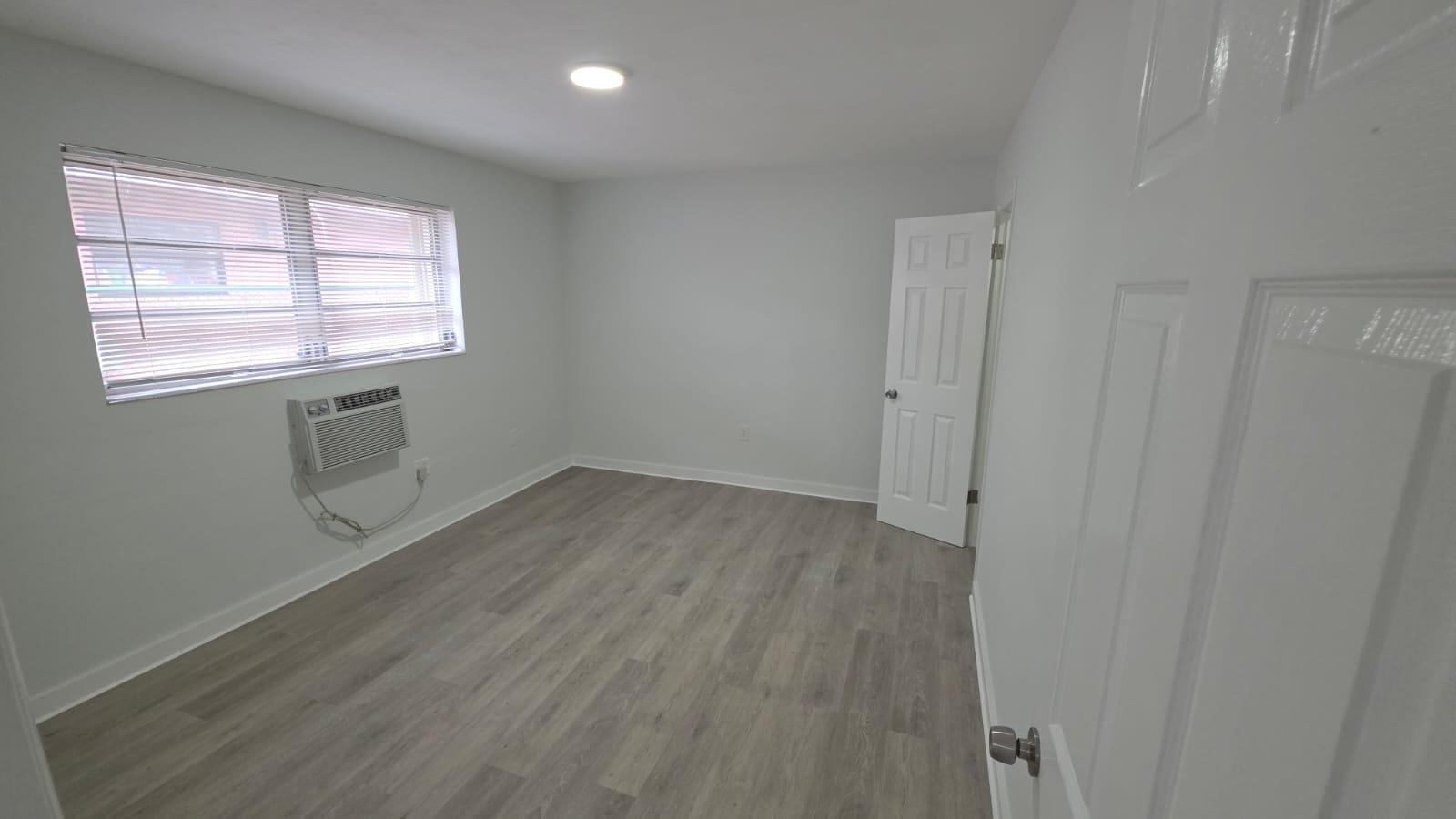 7624 Pembroke Road, Unit C Miramar, FL 33023 - Photo 11 of 13 an empty room with wooden floor and windows