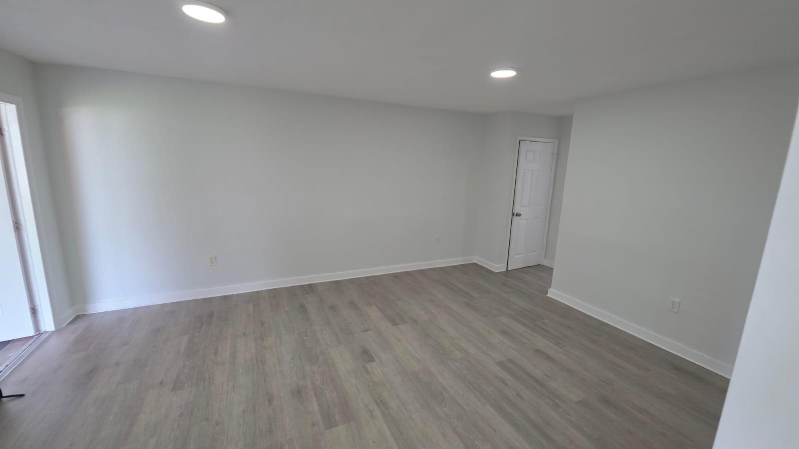 7624 Pembroke Road, Unit C Miramar, FL 33023 - Photo 3 of 13 an empty room with wooden floor and windows