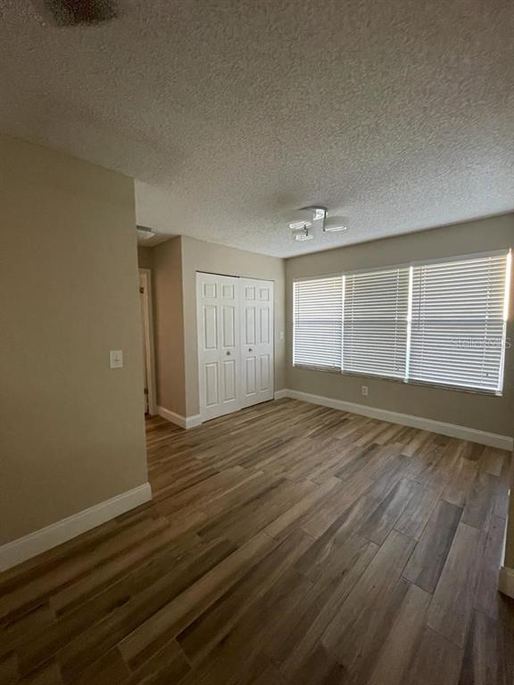 5148 Conroy Road, Unit 18 Orlando, FL 32811 - Photo 11 of 30 wooden floor in an empty room with a window