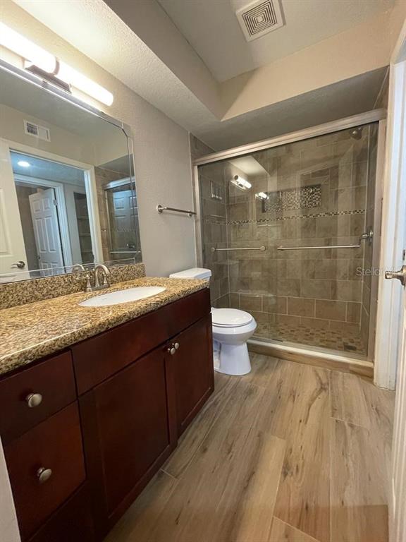 5148 Conroy Road, Unit 18 Orlando, FL 32811 - Photo 15 of 30 a bathroom with a double vanity sink a toilet and a mirror