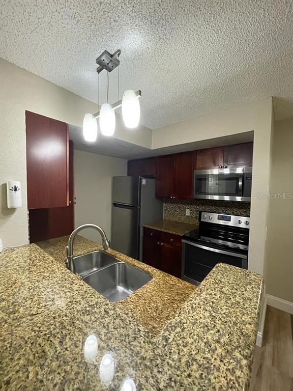 5148 Conroy Road, Unit 18 Orlando, FL 32811 - Photo 22 of 30 a kitchen with a sink and cabinets