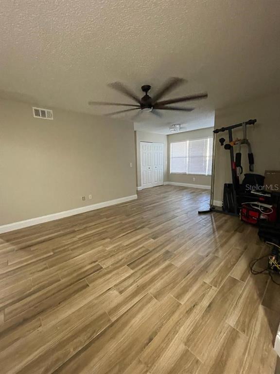 5148 Conroy Road, Unit 18 Orlando, FL 32811 - Photo 10 of 30 an empty room with wooden floor and a ceiling fan
