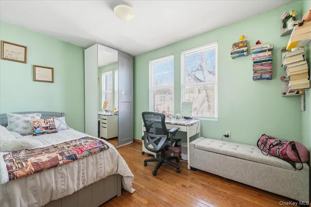 a bedroom with a bed and a mirror on the dresser