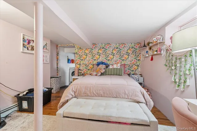 a bedroom with a bed a dresser and a flat screen tv