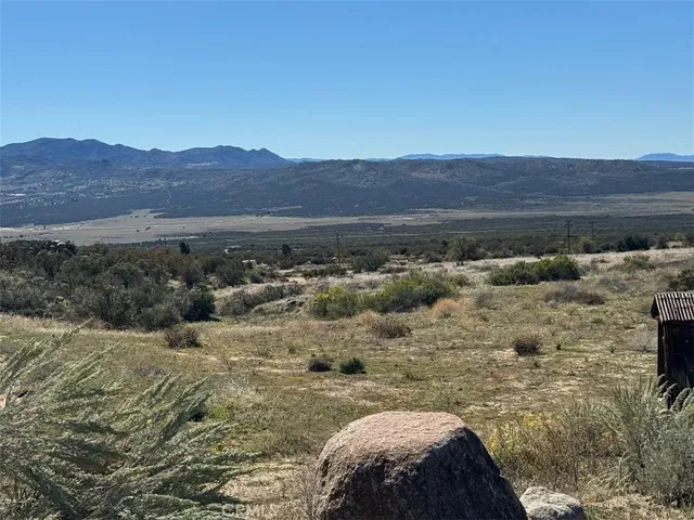 a view of a large mountain with mountains in the background