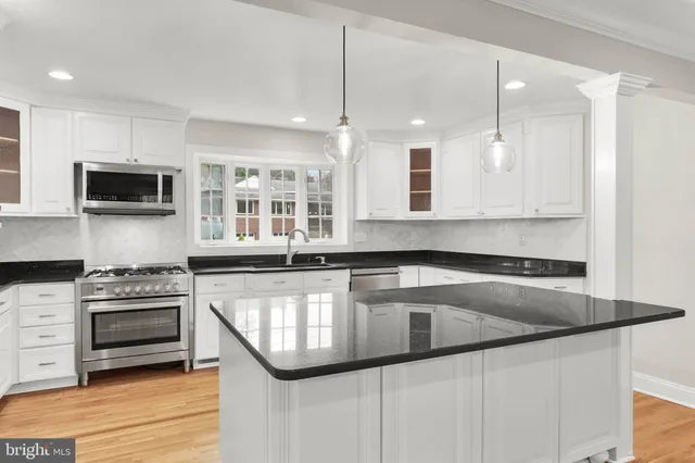 a kitchen with granite countertop a sink a stove and cabinets