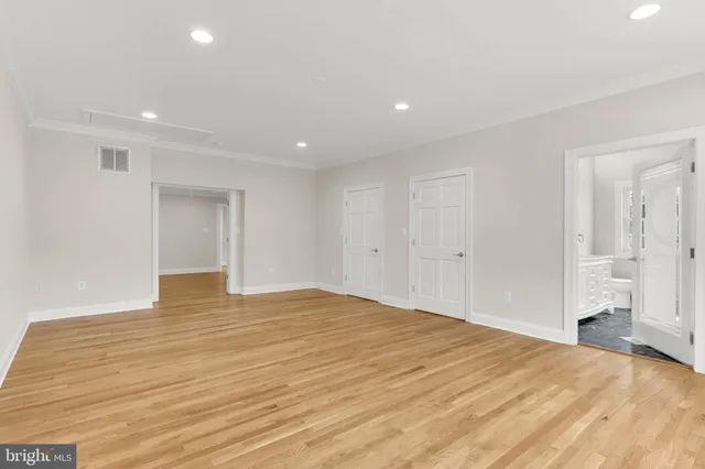 a view of empty room with wooden floor and windows