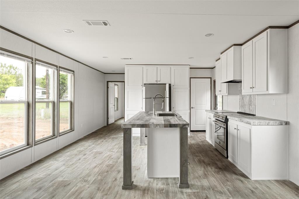 3606 Hilltop Road Granbury, TX 76048 - Photo 12 of 25 a kitchen with stainless steel appliances kitchen island granite countertop a stove a sink and a refrigerator