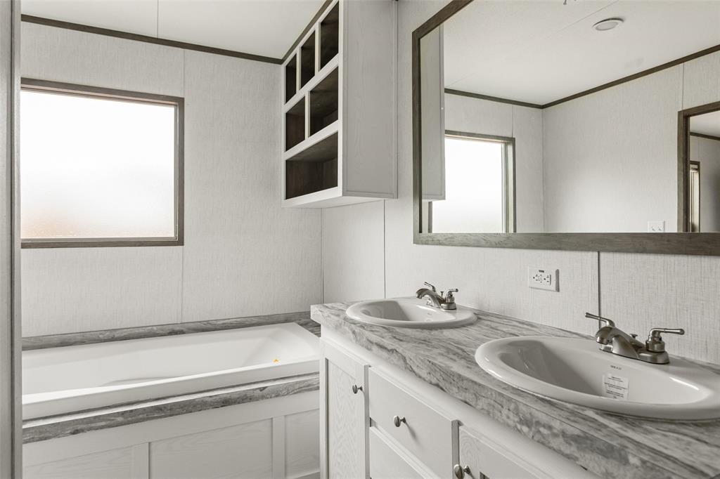 3606 Hilltop Road Granbury, TX 76048 - Photo 19 of 25 a bathroom with a sink and a mirror