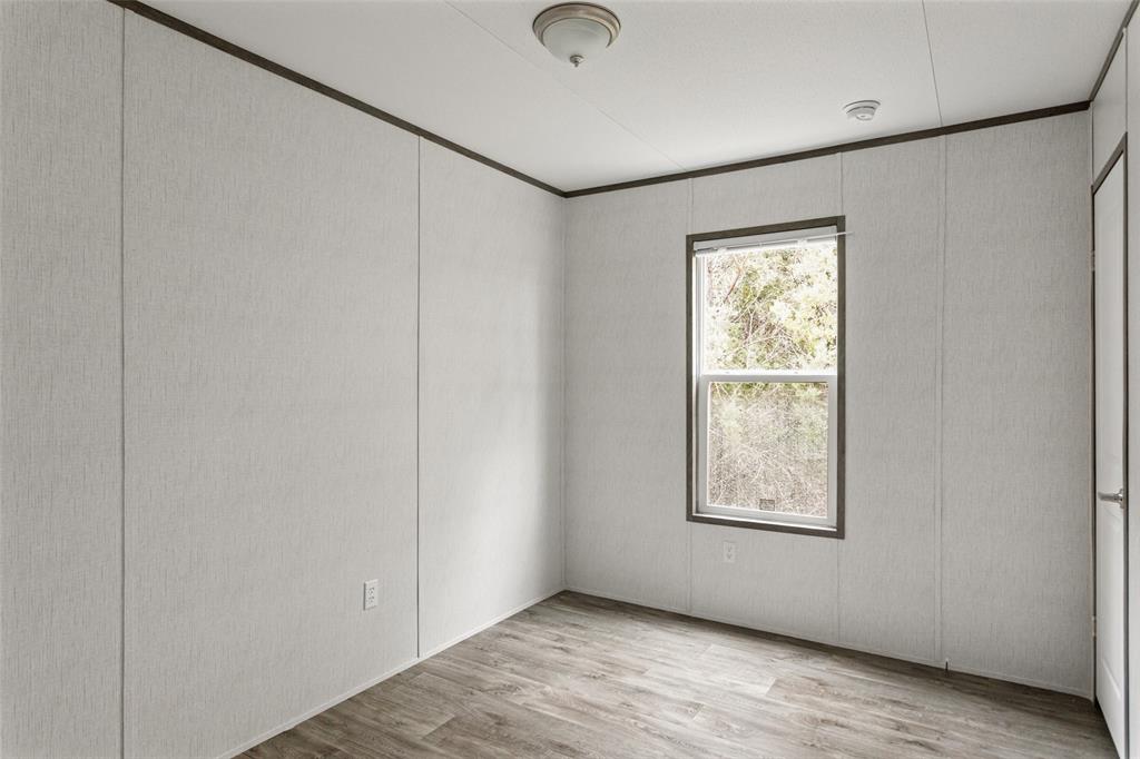 3606 Hilltop Road Granbury, TX 76048 - Photo 20 of 25 a view of an empty room with wooden floor and a window