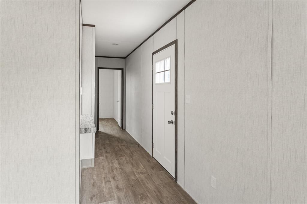 3606 Hilltop Road Granbury, TX 76048 - Photo 6 of 25 a view of a hallway with wooden floor and a bathroom
