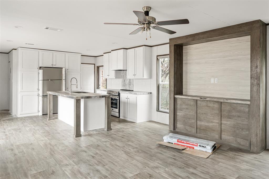 3606 Hilltop Road Granbury, TX 76048 - Photo 7 of 25 a kitchen with kitchen island white cabinets and refrigerator