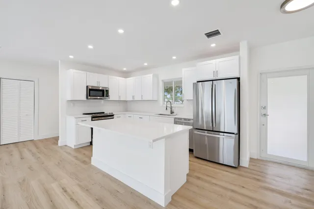 a kitchen with stainless steel appliances a refrigerator and a stove top oven