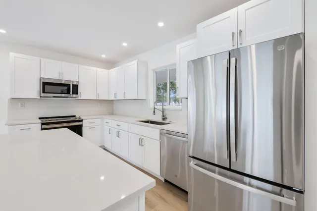 a kitchen with stainless steel appliances a refrigerator sink and microwave