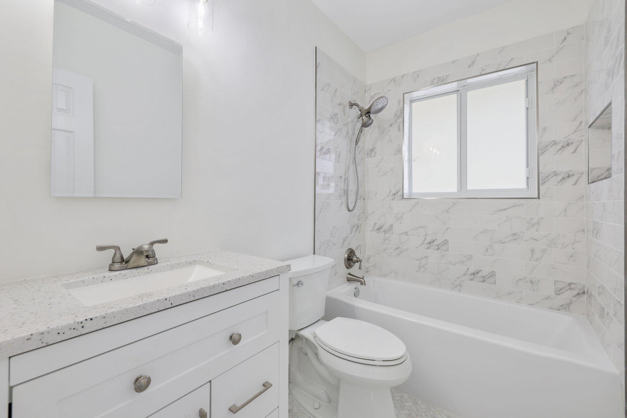 1198 Southwest 3rd Street Boca Raton, FL 33486 - Photo 17 of 29 a bathroom with a granite countertop sink a toilet and bathtub