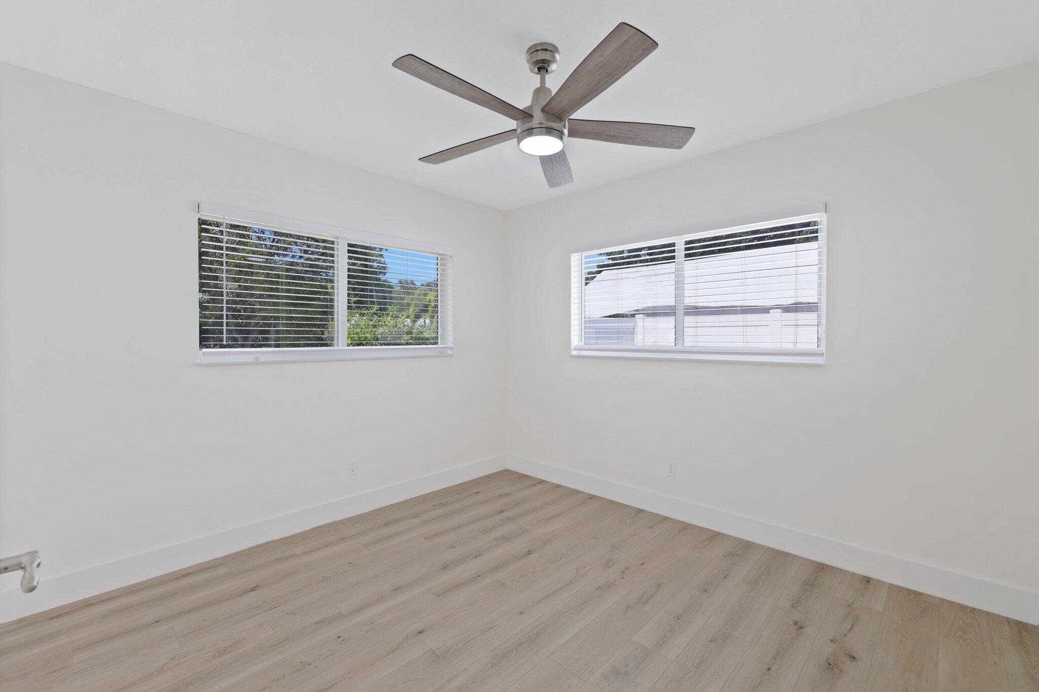 1198 Southwest 3rd Street Boca Raton, FL 33486 - Photo 18 of 29 a view of an empty room with wooden floor and ceiling fan