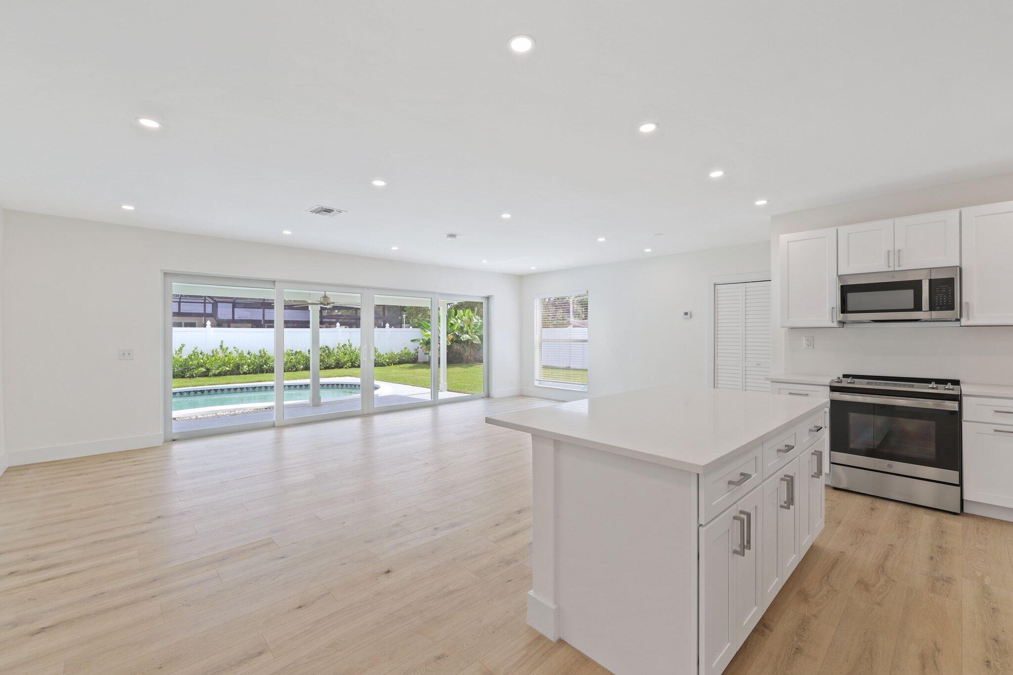 1198 Southwest 3rd Street Boca Raton, FL 33486 - Photo 7 of 29 a kitchen with stainless steel appliances a stove sink and microwave