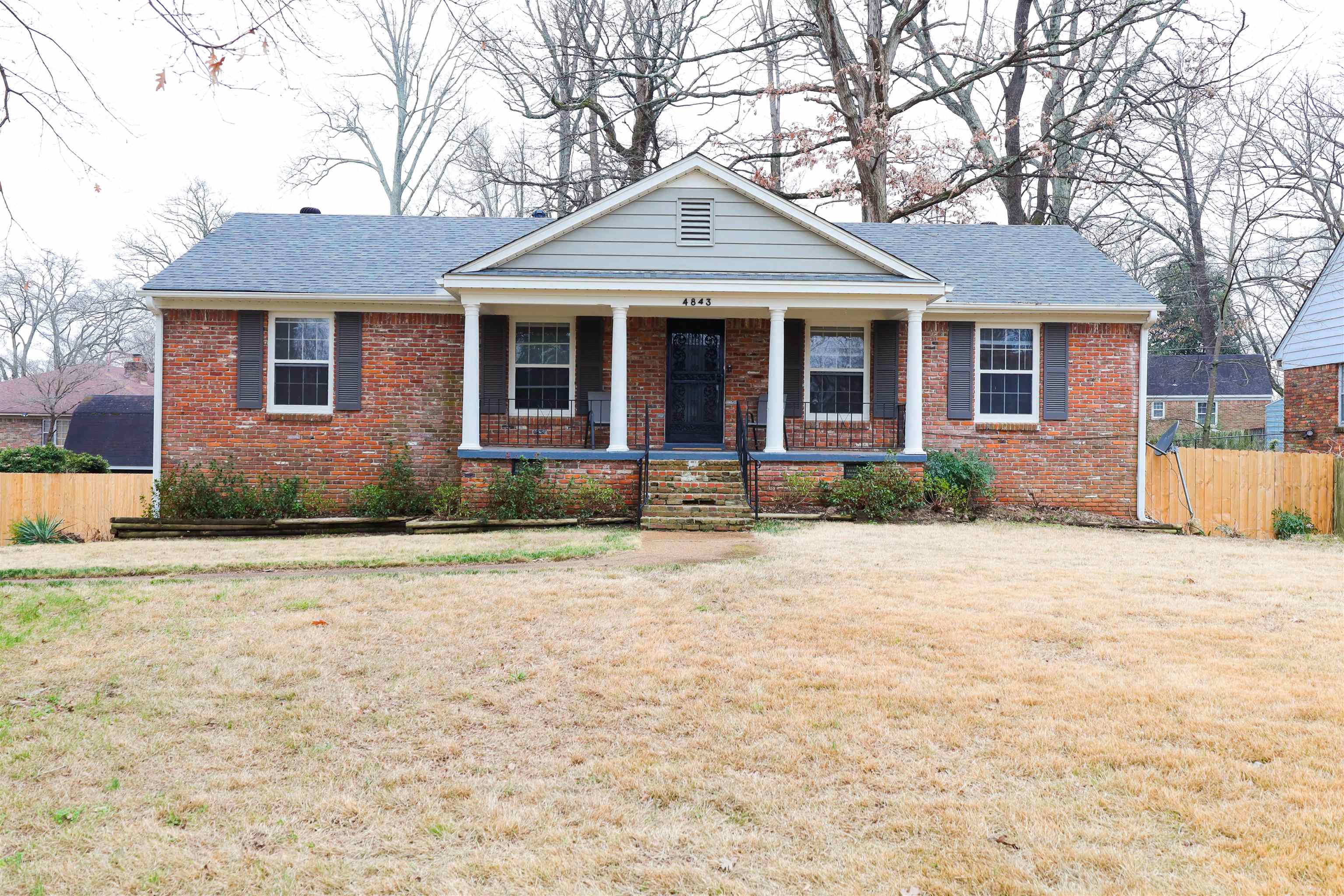 View of front of home with covered porch and a front lawn