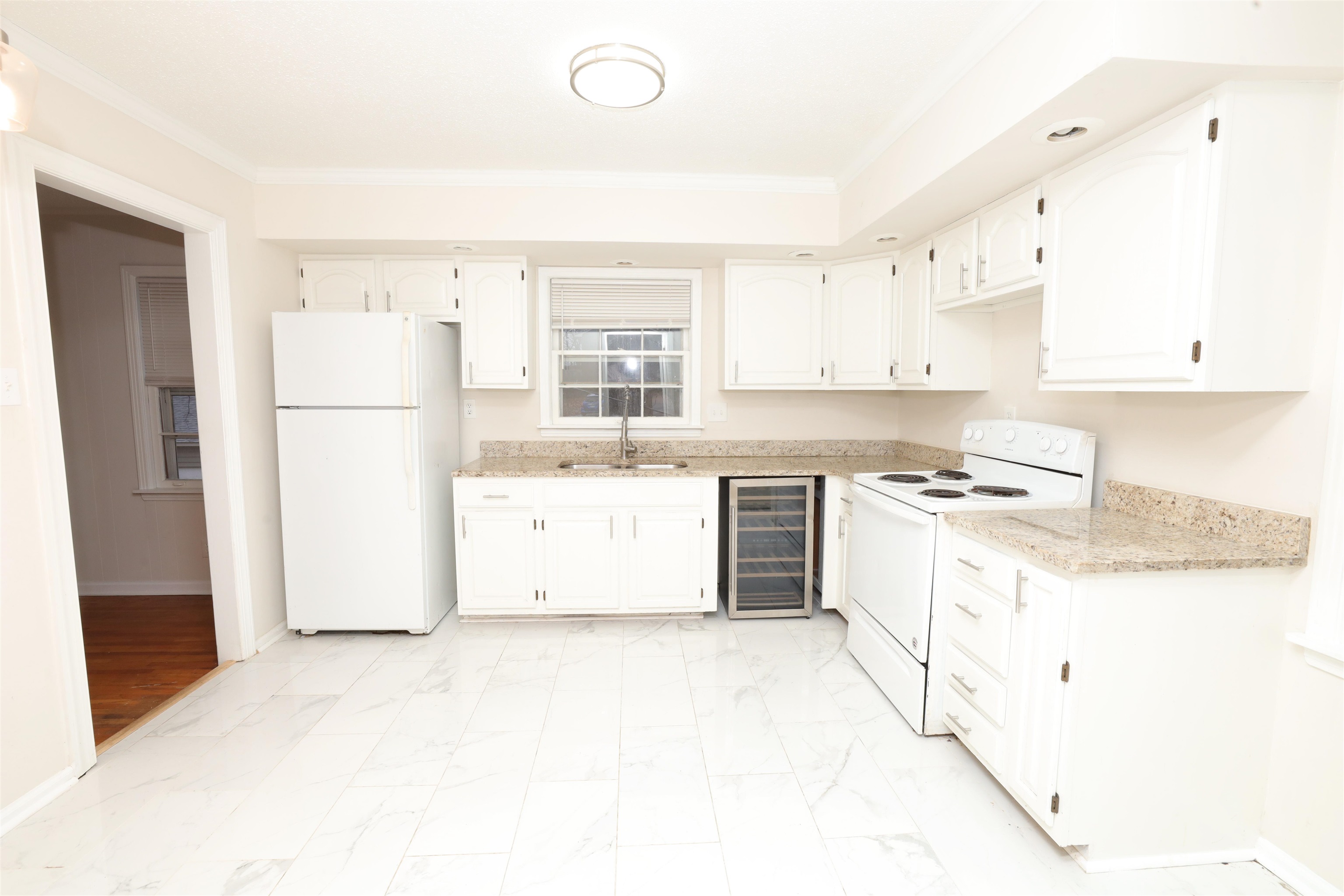 4843 Rolling Fields Drive Memphis, TN 38128 - Photo 6 of 22 Kitchen featuring sink, white appliances, ornamental molding, white cabinets, and beverage cooler