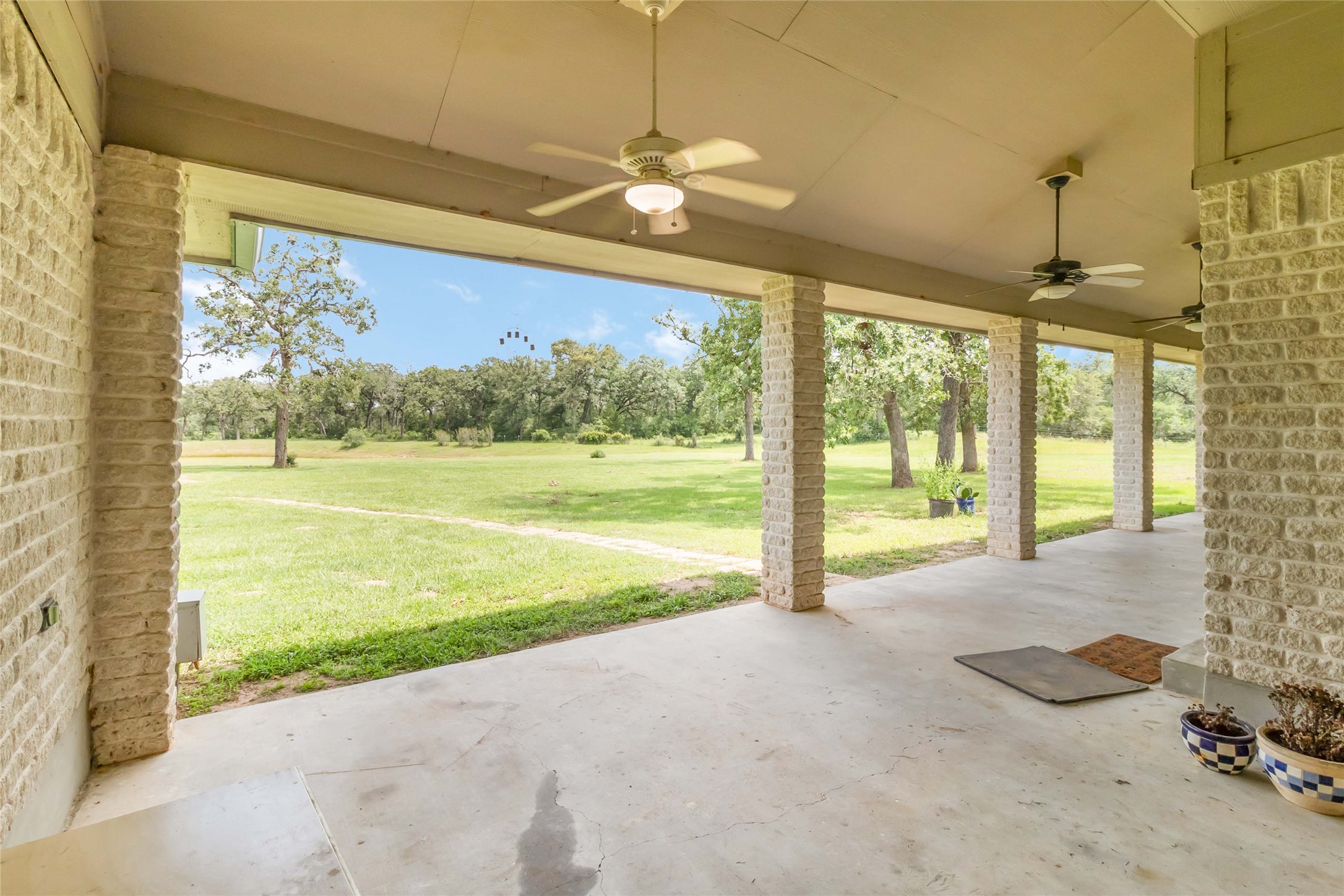 1208 Jeddo Road Rosanky, TX 78953 - Photo 4 of 40 A spacious covered patio invites peaceful outdoor living with sprawling green space beyond.
