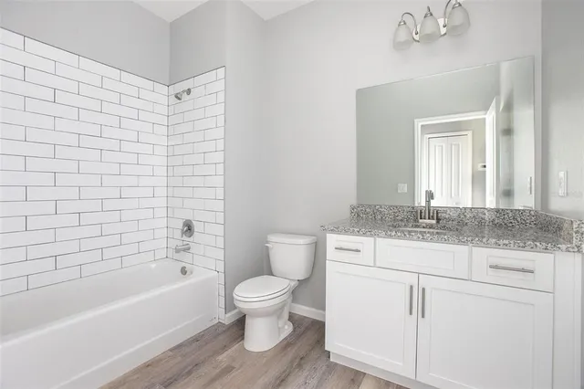 a bathroom with a granite countertop toilet a sink and bathtub
