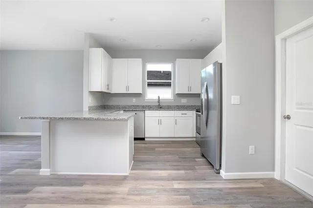 a kitchen with stainless steel appliances granite countertop a stove a sink and a refrigerator