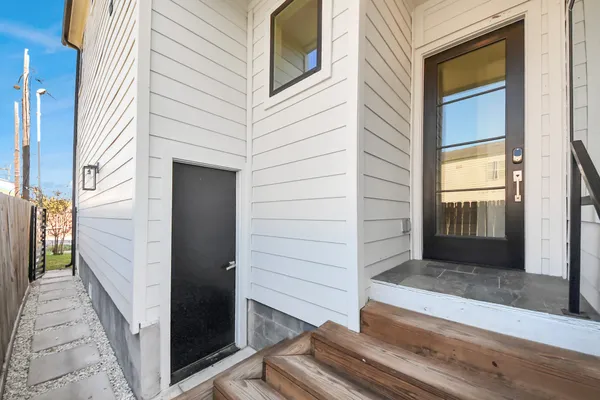a dining room with wooden floor a chandelier a glass table and chairs