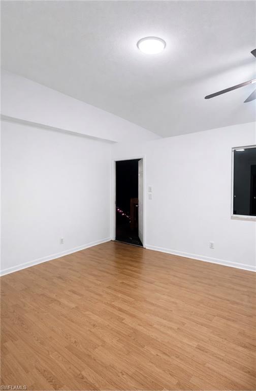 a view of an empty room with wooden floor and closet