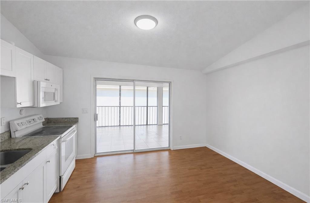5424 16th Place Southwest, Unit C3 Naples, FL 34116 - Photo 2 of 7 a view of a kitchen with a sink and dishwasher with wooden floor