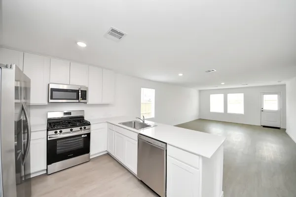 a kitchen with granite countertop a sink stainless steel appliances and cabinets
