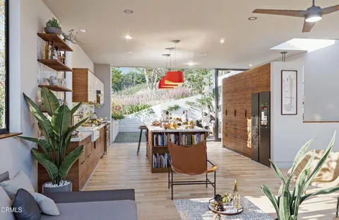 a room with stainless steel appliances kitchen island granite countertop a sink and cabinets