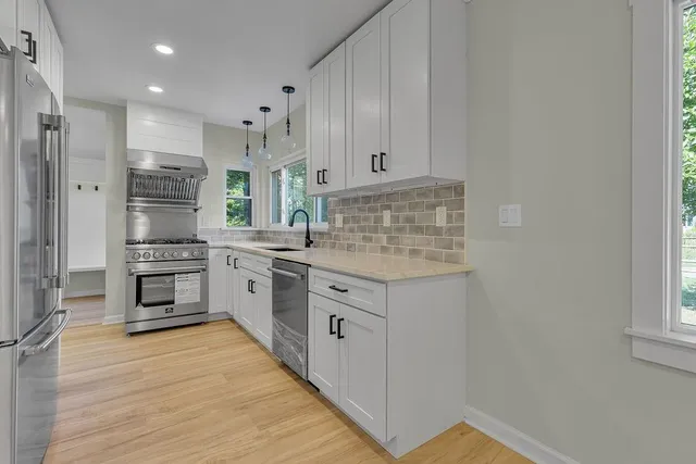 a kitchen with stainless steel appliances granite countertop a stove and a refrigerator