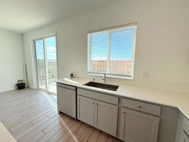 a kitchen with a sink and wooden floor