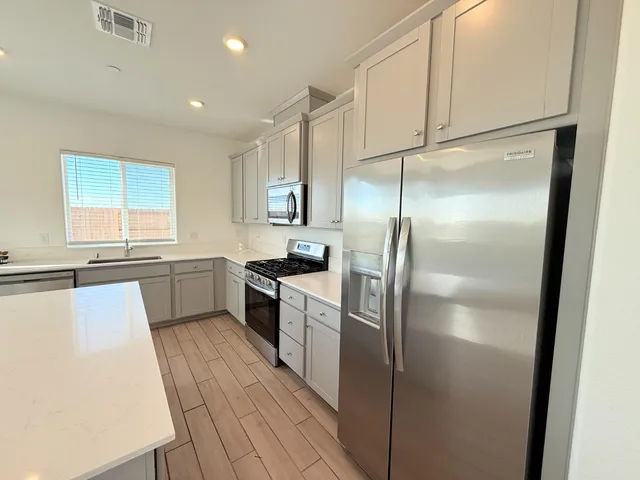 a kitchen with a refrigerator a sink and cabinets