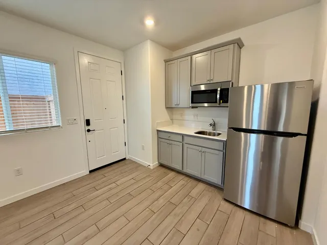 a kitchen with a refrigerator stove and wooden cabinets
