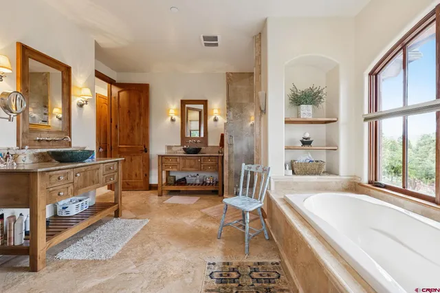 a spacious bedroom with a bed a table and a large window